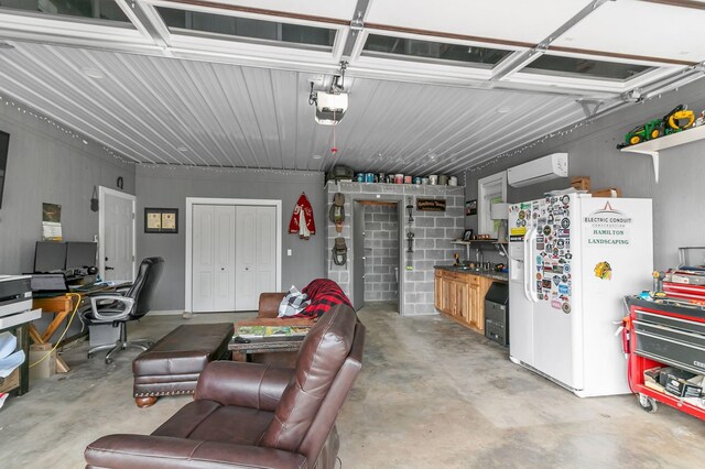 garage featuring a garage door opener, white refrigerator with ice dispenser, and a wall unit AC