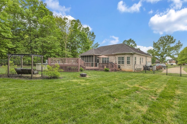 back of house with brick siding, a wooden deck, a lawn, and fence