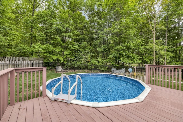 view of swimming pool featuring a wooden deck, a fenced backyard, and a fenced in pool