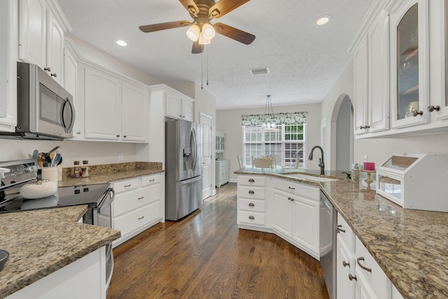 kitchen featuring white cabinets, stainless steel appliances, a peninsula, and a sink