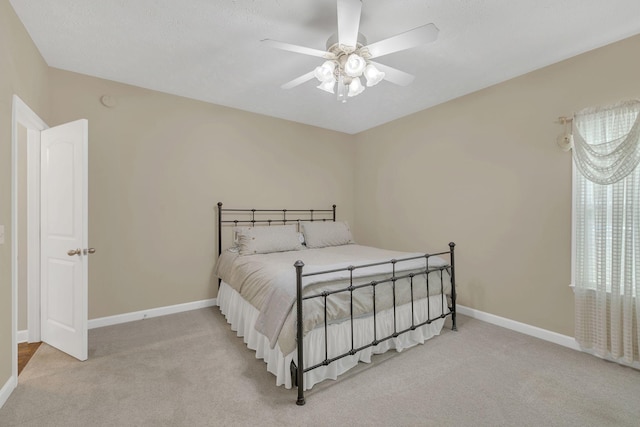 bedroom with a ceiling fan, carpet flooring, and baseboards