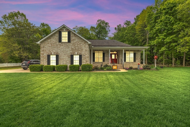 traditional home featuring brick siding, a porch, and a yard