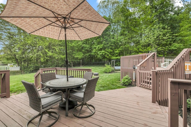 deck with a yard, outdoor dining area, and a fenced backyard