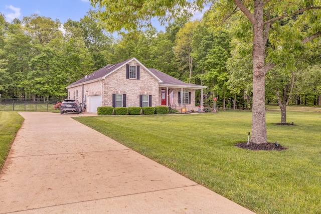 view of front facade with concrete driveway, a front lawn, brick siding, and fence