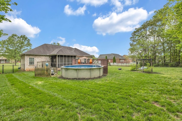 exterior space with a fenced in pool, a fenced backyard, a sunroom, and a lawn