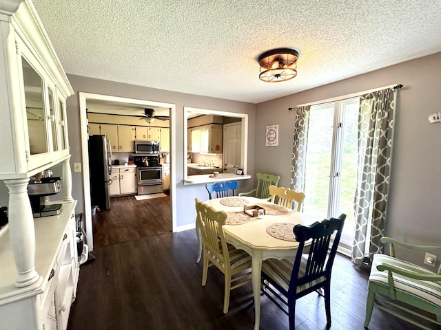 dining space with dark wood-style flooring, ceiling fan, and a textured ceiling