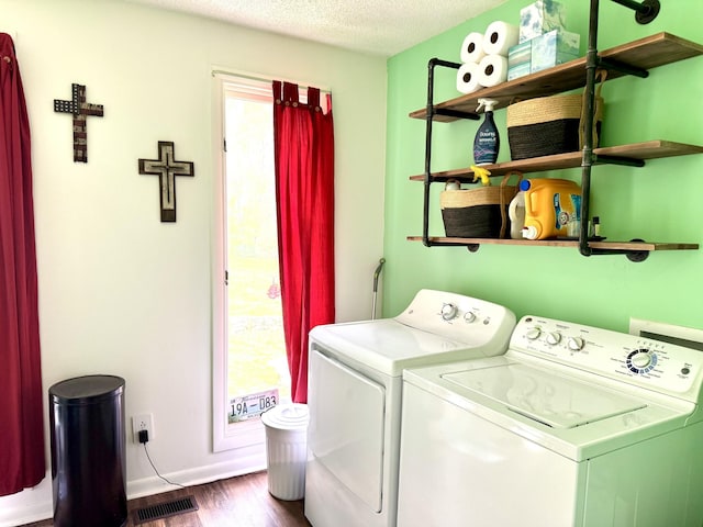 washroom with a textured ceiling, independent washer and dryer, visible vents, dark wood-style floors, and laundry area