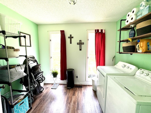clothes washing area with a textured ceiling, independent washer and dryer, baseboards, wood finished floors, and laundry area