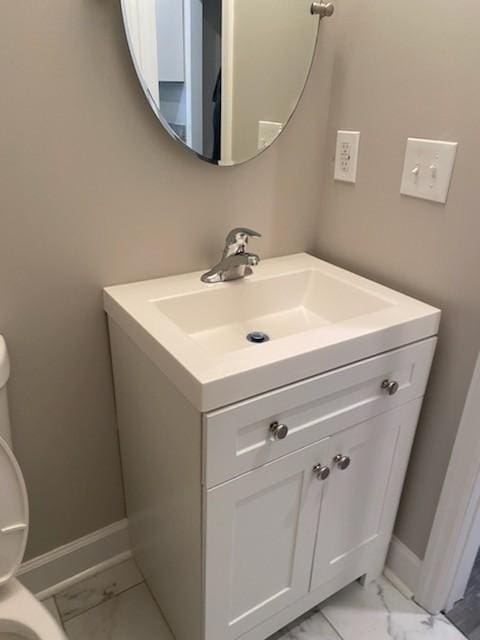 bathroom featuring baseboards, toilet, vanity, and marble finish floor