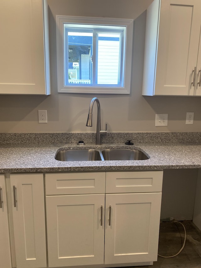 kitchen featuring white cabinetry and a sink