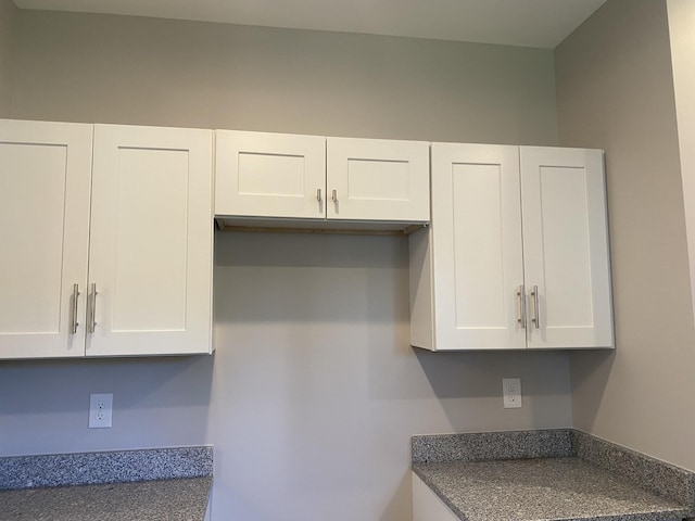 kitchen featuring dark countertops and white cabinetry
