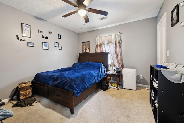 bedroom featuring baseboards, visible vents, a ceiling fan, and light carpet