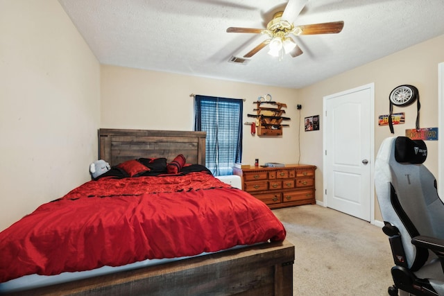 bedroom featuring visible vents, ceiling fan, carpet floors, and a textured ceiling