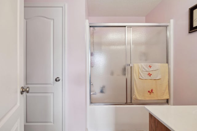 bathroom with bath / shower combo with glass door and vanity