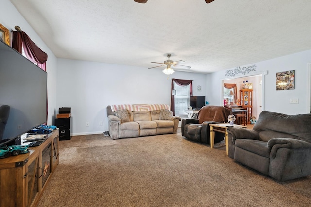 living area with a ceiling fan, carpet, and a textured ceiling