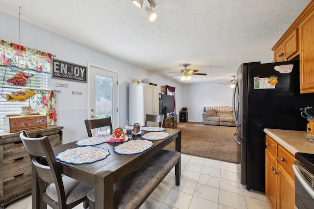 dining area with light carpet and a ceiling fan