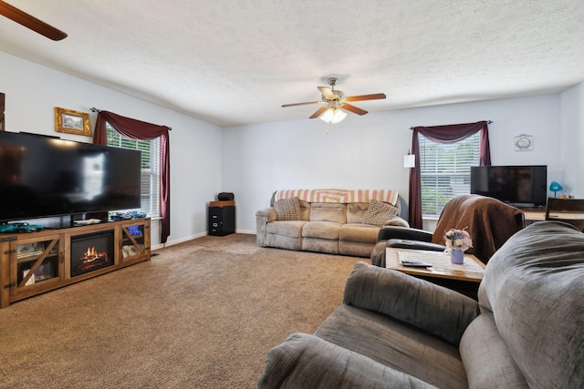carpeted living room featuring a textured ceiling, ceiling fan, and baseboards