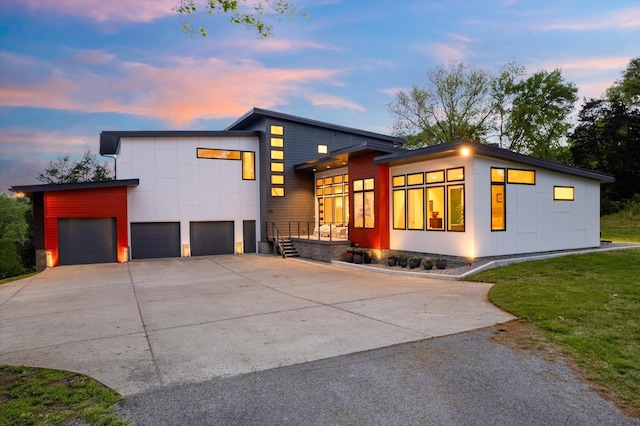 view of front of house featuring a lawn, driveway, a garage, and board and batten siding