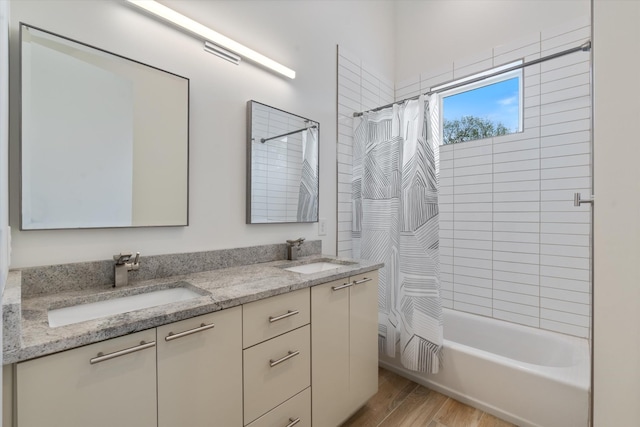 bathroom with double vanity, wood finished floors, shower / bath combination with curtain, and a sink