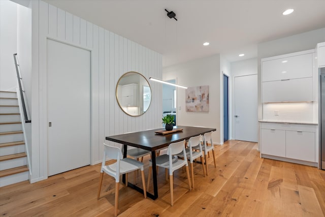 dining space featuring light wood finished floors, stairs, and recessed lighting
