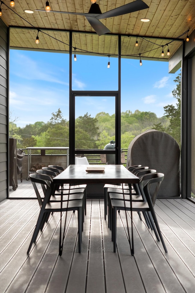 sunroom with track lighting, outdoor dining space, and a ceiling fan