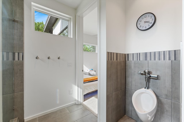 bathroom featuring tile walls, tile patterned floors, and ensuite bathroom