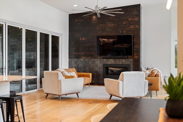 living area with a ceiling fan, wood finished floors, a large fireplace, and recessed lighting