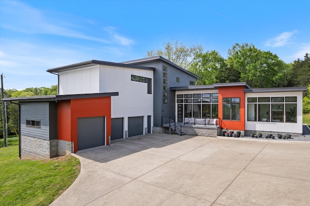 exterior space with board and batten siding, driveway, and a sunroom