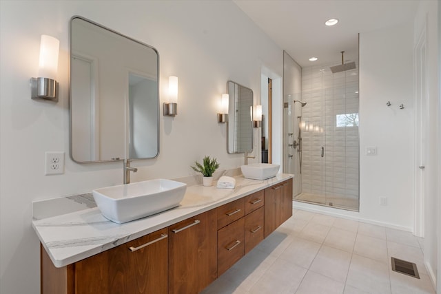full bathroom with a sink, double vanity, visible vents, a stall shower, and tile patterned flooring