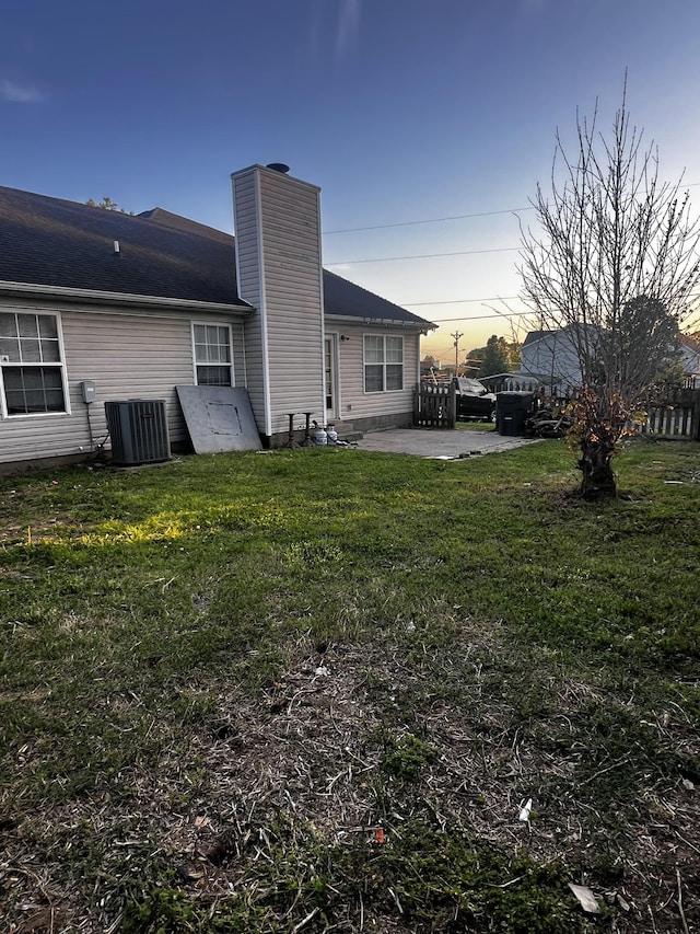 914 Lavergne Ln, La Vergne, TN 37086 - back of house at dusk with a patio area, cooling unit, a lawn, a chimney, and fence