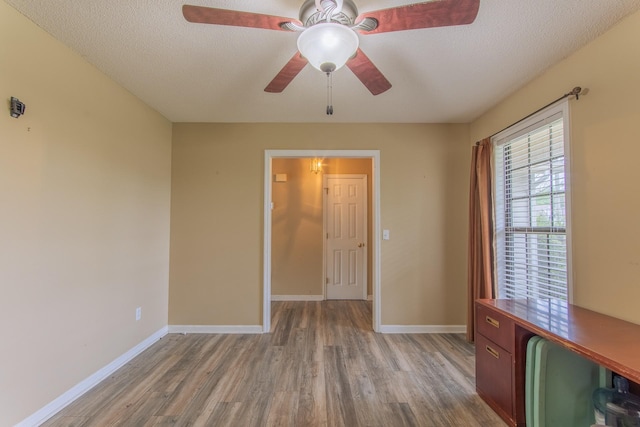 empty room with baseboards, ceiling fan, and light wood-style floors