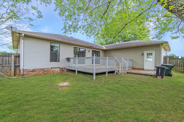 rear view of house with a lawn, a wooden deck, crawl space, and fence