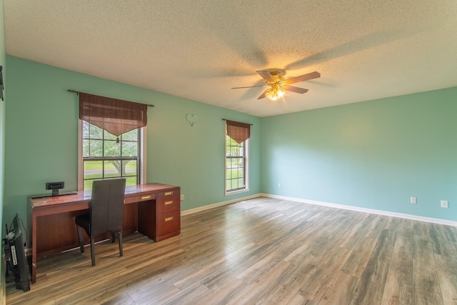 office with a ceiling fan, baseboards, wood finished floors, and a textured ceiling