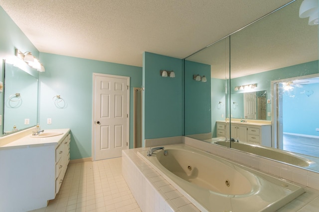 full bath featuring a textured ceiling, a sink, two vanities, a jetted tub, and tile patterned flooring