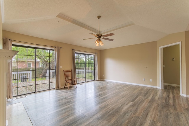 empty room with baseboards, wood finished floors, a ceiling fan, and a textured ceiling