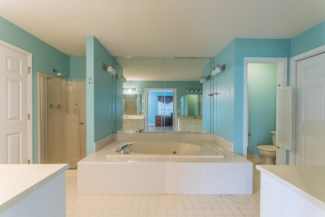 full bathroom with vanity, toilet, a stall shower, a garden tub, and tile patterned flooring