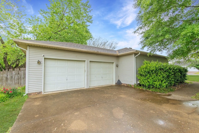 garage with driveway and fence