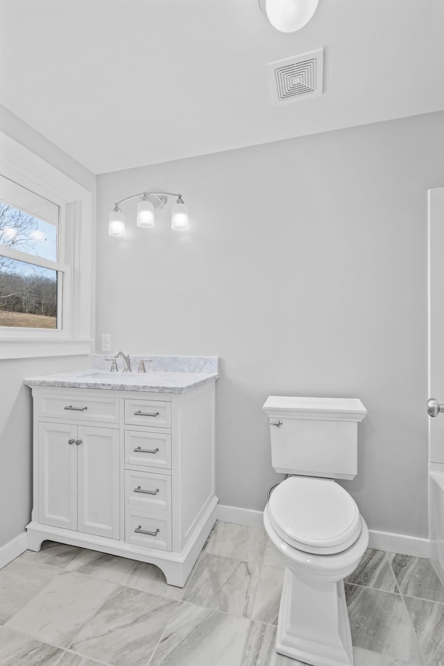 bathroom with visible vents, baseboards, toilet, vanity, and marble finish floor