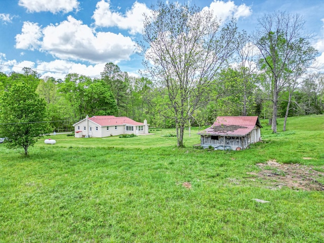 view of yard featuring an outbuilding and a view of trees