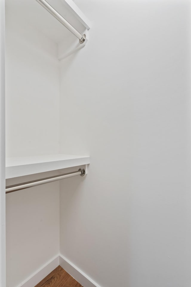 walk in closet with wood finished floors