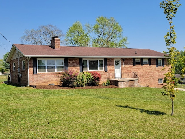 ranch-style home with brick siding, a chimney, a shingled roof, and a front lawn