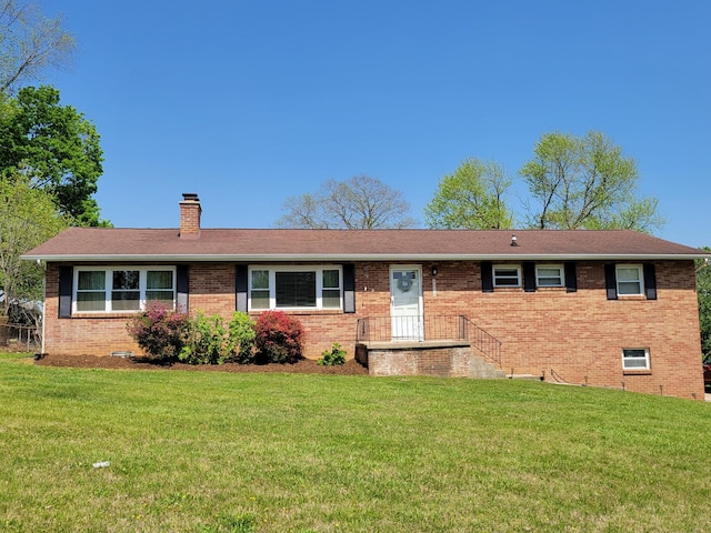 ranch-style house with a chimney, a front lawn, and brick siding