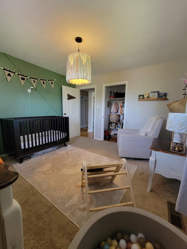 bedroom featuring a chandelier, visible vents, carpet, and a closet