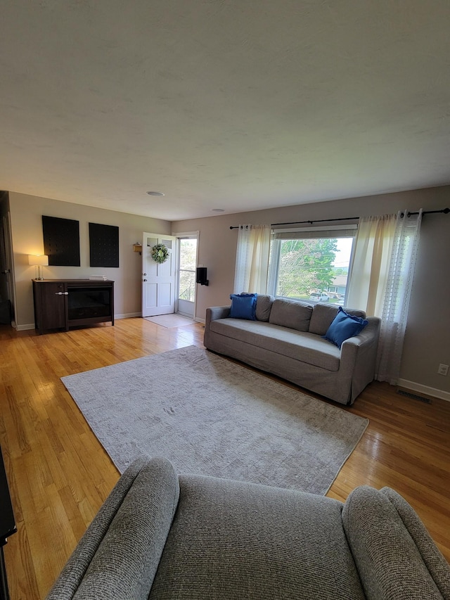 living room featuring light wood-type flooring and baseboards