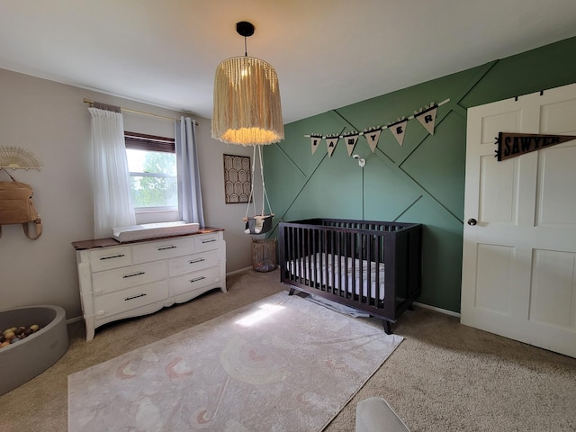 bedroom featuring a nursery area and light carpet