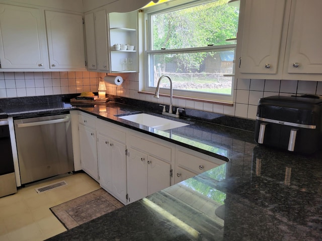 kitchen featuring white cabinets, a sink, tasteful backsplash, stainless steel dishwasher, and visible vents