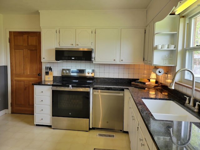 kitchen featuring visible vents, tasteful backsplash, a sink, stainless steel appliances, and white cabinetry