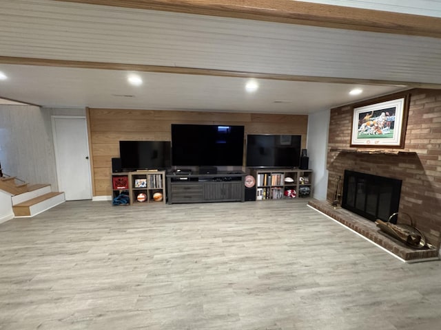 living room with wooden walls, a fireplace, recessed lighting, and wood finished floors
