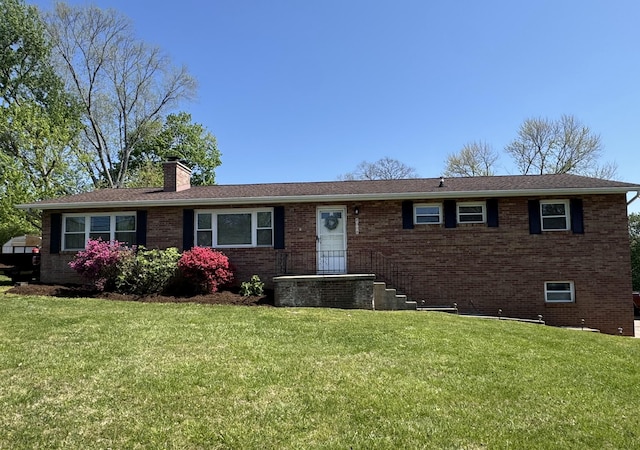 ranch-style home with brick siding, a chimney, and a front yard
