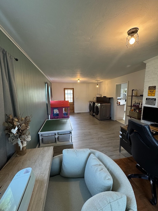 living room featuring crown molding, a textured ceiling, independent washer and dryer, and wood finished floors